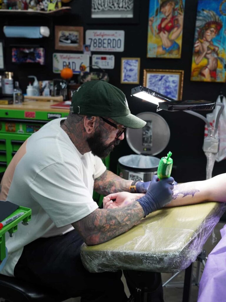Sixer tattooing a client at Golden Child Tattoo